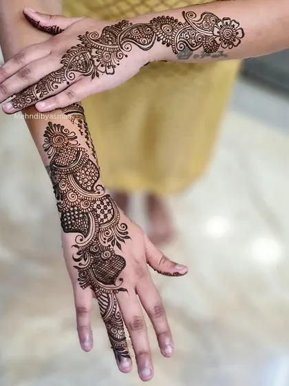 A mix of Arabic and Indian styles, with a bold peacock-inspired design on one hand and a flowing vine on the other.