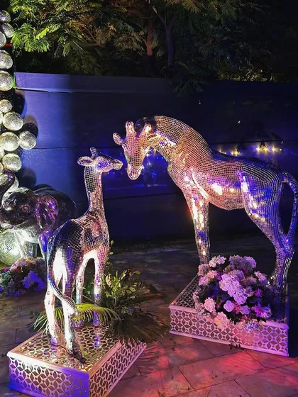 Adding to the glittering menagerie, these mirror-work giraffe statues bring a touch of whimsical glamour to the Sangeet decor.