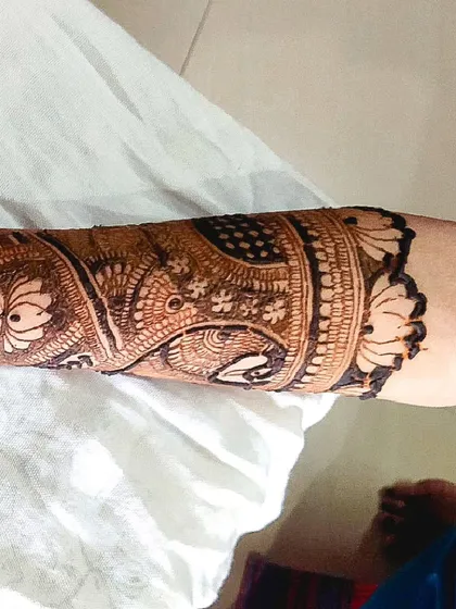 A close-up view of a detailed armband design. This section of a full-arm mehandi showcases intricate work with swans and lotuses, demonstrating the fine details I include in my larger pieces.