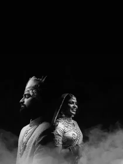 A dramatic black and white portrait of the couple surrounded by smoke. This artistic shot has a cinematic and timeless quality.