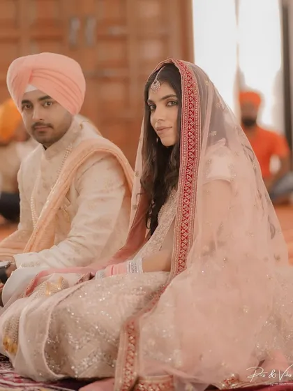 A beautiful portrait of the couple during their Sikh wedding ceremony. The bride glances towards the camera, her delicate veil and pastel lehenga looking ethereal.