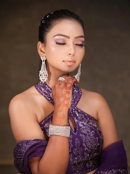 A close up on the makeup, showing the flawless base and the precise application of the purple liner. The soft shimmer on the lid adds a beautiful finishing touch.