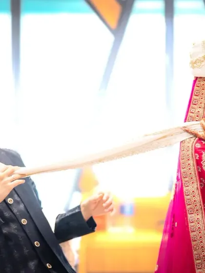 A fun, tug-of-war with the groom's turban sash. This kind of playful interaction makes for fantastic, dynamic wedding photos that are full of personality.