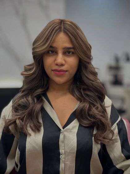 A full-face view of the client's caramel brown transformation, showing how the color brightens her complexion.