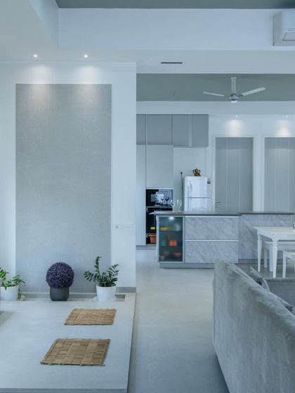 A view of the "Grey House" project, showing how different shades and textures of grey are used to create a cohesive and calming living space, from the walls to the kitchen cabinetry.