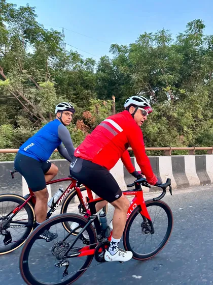 An action shot of two members riding together on a flyover.