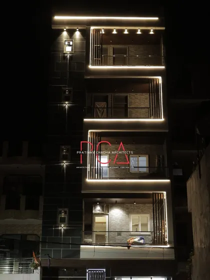 A full view of 'The Cursive Abode' at night. The lighting design accentuates each floor, creating a rhythmic and cohesive architectural statement that is both elegant and modern.