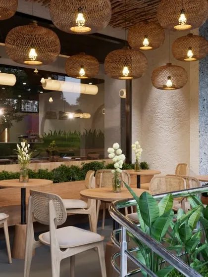Stepping into the semi-outdoor seating area, we created a peaceful retreat. We used woven rattan pendant lights and light wood furniture to establish a warm, eco-elegant feel. The abundant greenery acts as a natural separator, offering guests a sense of privacy and calm.