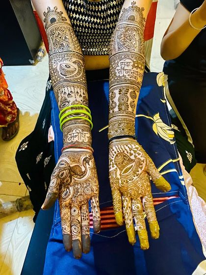 A full bridal design that incorporates personal elements like names, alongside traditional motifs like dholki and peacocks. The result is a piece that is both classic and unique.