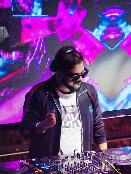 In the shadows of sound, I speak in rhythm. A cool shot of me at the console with psychedelic visuals on the screen behind me.