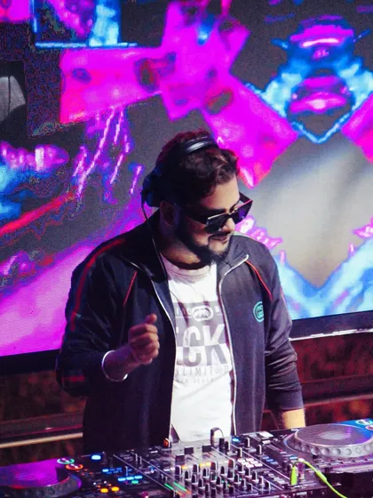 In the shadows of sound, I speak in rhythm. A cool shot of me at the console with psychedelic visuals on the screen behind me.