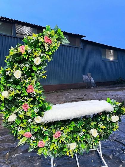 A custom-made moon-shaped seat or 'jhoola' decorated with lush greenery and flowers. This is a unique prop I provide for Ganpati decorations or baby photoshoots.
