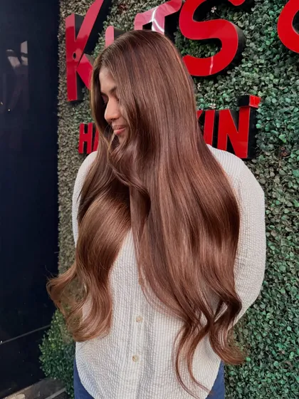 A lovely candid shot of our bride to be enjoying her new hair. The color looks stunning against our salon's greenery wall.