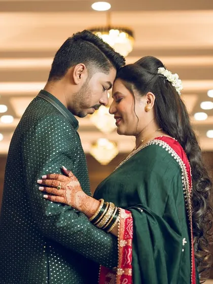 An intimate indoor portrait of a couple, their foreheads touching, with beautiful architectural lighting in the background.