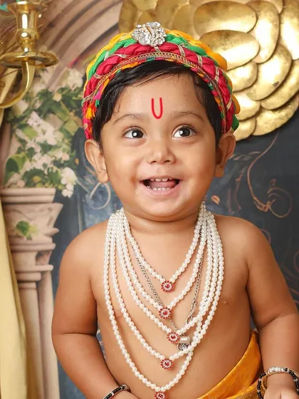 The pure, innocent smile of a little one dressed as Kanha is truly divine. This close-up from a Janmashtami themed shoot captures the joyful spirit that makes these sessions so special.