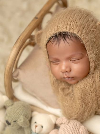 The smiling Simba. This close-up of a newborn in a bear outfit shows the peaceful and content expressions they make in their sleep.