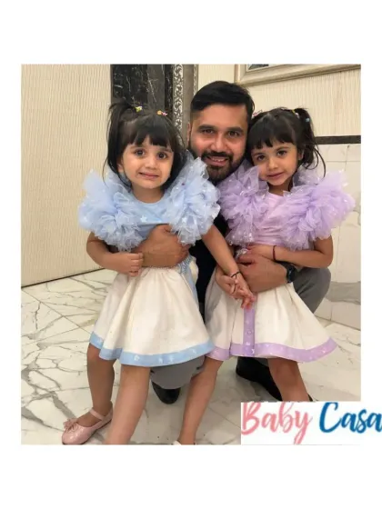 Daddy's girls in their matching pastel ruffled tops and white skirts. We can create custom looks for any occasion, ensuring your little ones are always dressed to impress.