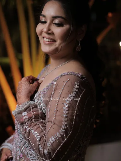 A happy, smiling client enjoying her sangeet. Her makeup is soft and radiant, designed to make her feel comfortable and beautiful throughout the event.
