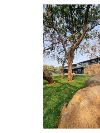 The house seen from behind ancient rocks on the property. We believe in retaining the geological history of a place, letting the natural elements become part of the home's story.