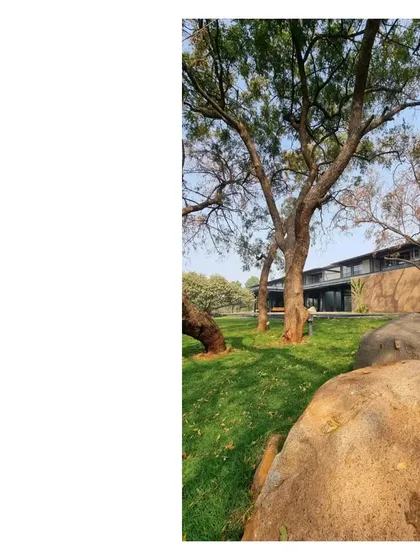 The house seen from behind ancient rocks on the property. We believe in retaining the geological history of a place, letting the natural elements become part of the home's story.