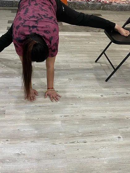 A deeper split stretch using the chair, demonstrating how we adapt poses for different flexibility levels.