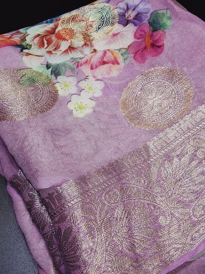 A beautiful viscose saree in a soft lavender color, featuring a combination of digital floral prints and woven zari butti. The elegant zari border completes the look, making it perfect for festive occasions.