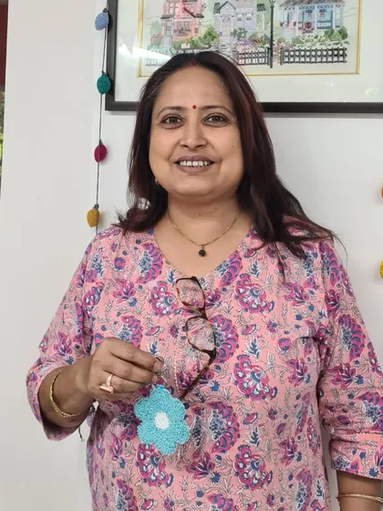 A participant holding her lovely blue flower charm, a simple yet beautiful creation.