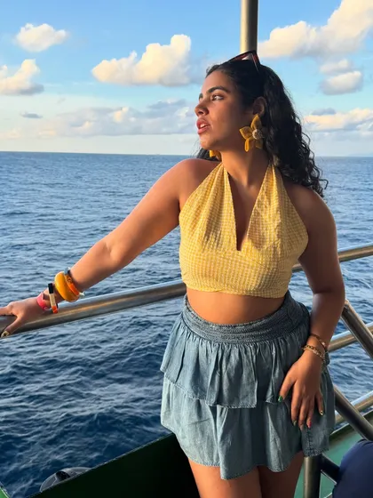 A full-body shot on the cruise. The tiered denim skirt adds a playful touch to the look.