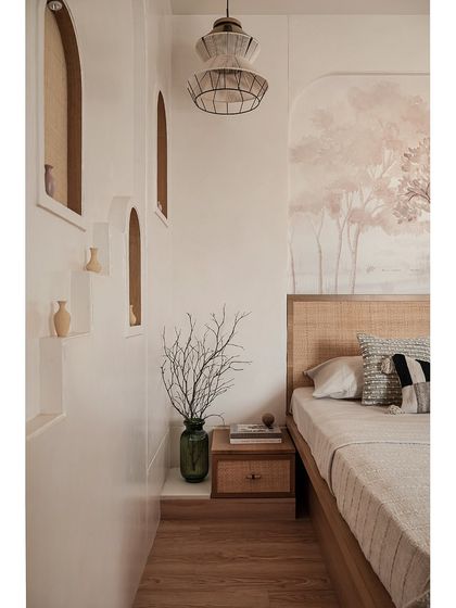 This view highlights the arched wall niches with cane detailing and micro-topped walls, which create a beautiful focal point. The layered textures and earthy tones give the master bedroom a calm, natural feel.