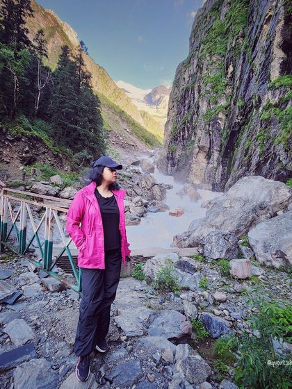 A moment of reflection by a rushing mountain stream. This outfit, with a bright pink waterproof jacket, is styled for both adventure and stunning photo opportunities.