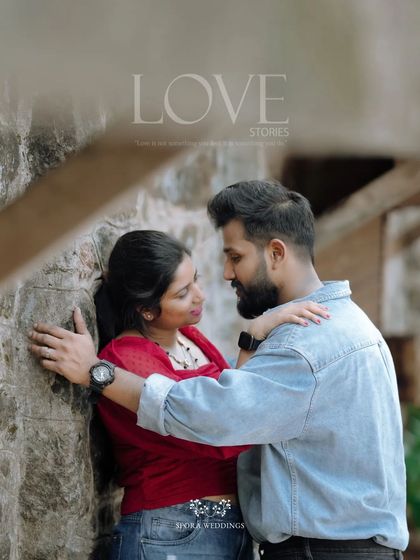 An intimate portrait of the couple, their faces close, framed by a stone wall and soft light.