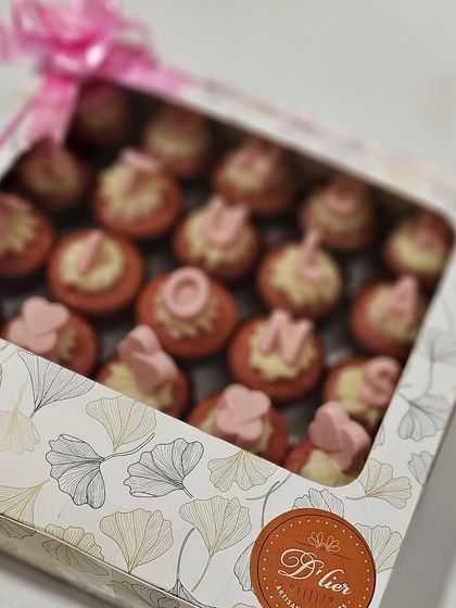 A beautifully packaged box of our custom whole wheat red velvet cupcakes, tied with a pink ribbon and ready for gifting.