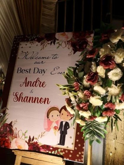 A personalized welcome sign is a wonderful touch for any wedding. This easel sign, adorned with a floral arrangement, greets guests with the couple's names and a charming illustration.
