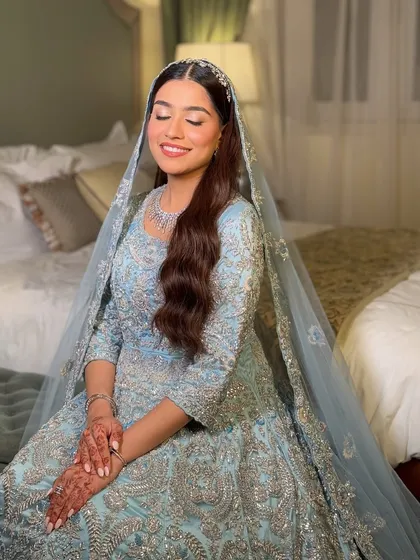 A serene moment of bridal bliss. The soft veil and gentle smile are paired with makeup that is equally soft and dreamy, perfect for a Nikah or reception.