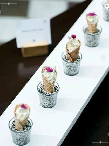 Miniature savoury ice cream cones, presented in individual glasses. This innovative appetiser plays with expectations, offering a surprising and delightful bite.