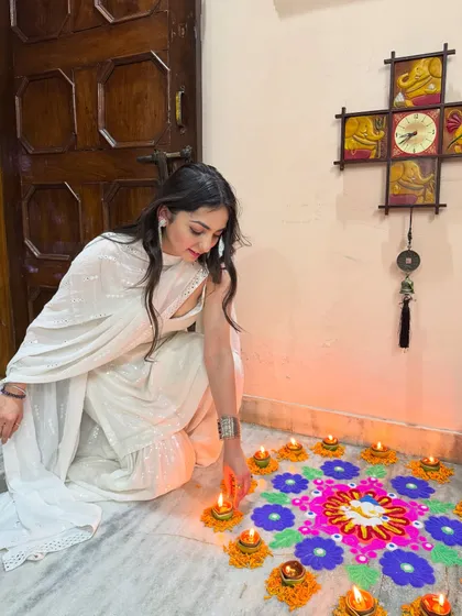 Lighting diyas for Diwali in an all-white sharara set. This is an example of creating authentic, festive content that resonates with the spirit of the occasion.