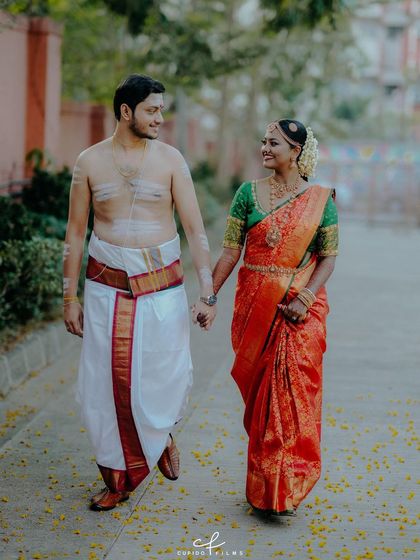 Venkatesh and Shilpa walk hand-in-hand after their traditional Tamil wedding ceremony. The groom's sacred markings and the bride's vibrant saree tell a story of culture and love.