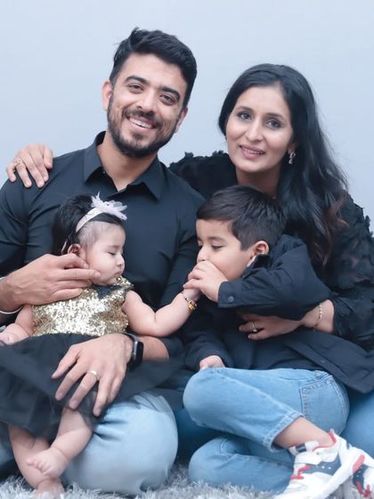 A brother's gentle kiss for his baby sister. This studio portrait showcases a beautiful, tender moment between siblings in a coordinated family outfit.