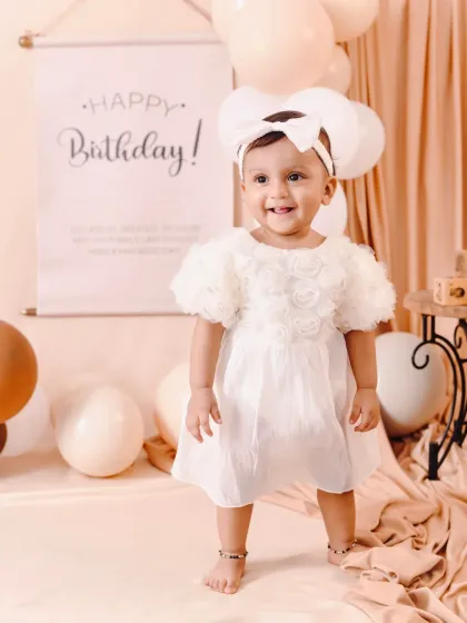 Standing tall and proud on her first birthday. This shot captures a huge milestone in a beautiful, light-filled studio setting.