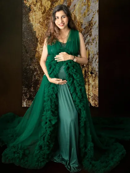 This rich green gown provides a beautiful contrast against the textured backdrop. This solo portrait is all about capturing the elegance and anticipation of motherhood.