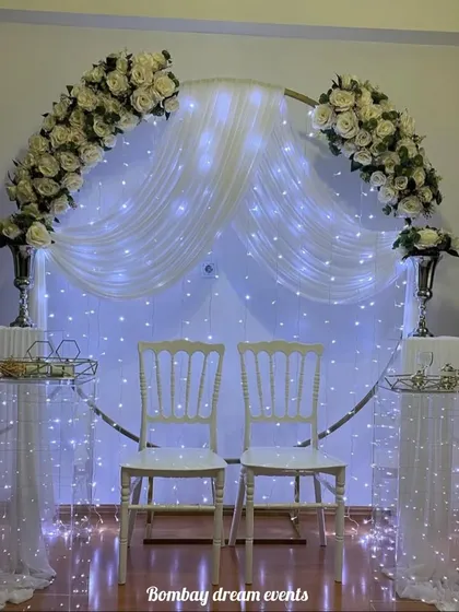 Another angle of the elegant white-themed anniversary decor, showing the beautiful floral arrangements and lighting.