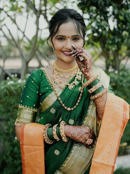 A smiling bride on her wedding day, her intricate mehendi is a beautiful part of her traditional look.