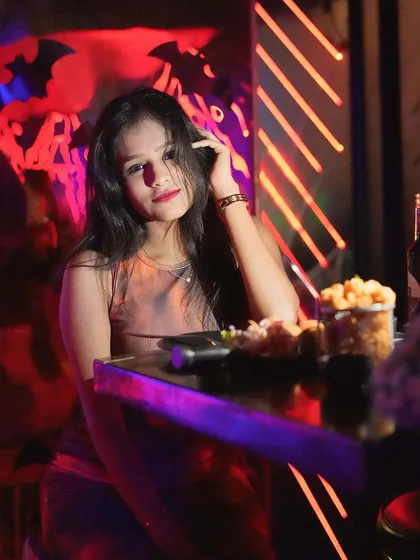 A guest enjoying the spooky, red-lit ambiance of our Halloween party.