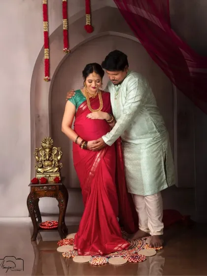 A beautiful couple's portrait in traditional attire. The partner's hand gently on her bump symbolizes his love and support on this sacred journey.
