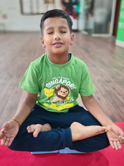 Finding a moment of calm. I teach simple meditation and breathing techniques, like this seated Padmasana (Lotus Pose), to help children manage their energy and improve their focus after a busy day.