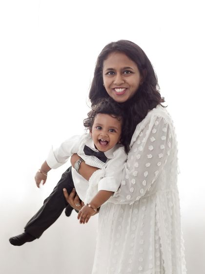A mother's joy is evident as she holds her laughing son, a beautiful candid moment.