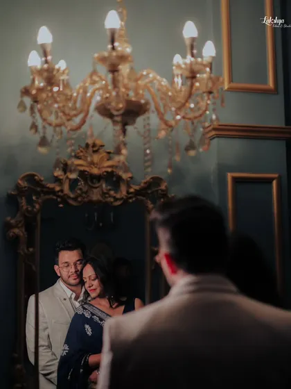 A sophisticated and creative shot using a mirror in a richly decorated room. The reflection adds a layer of storytelling and elegance to the portrait.