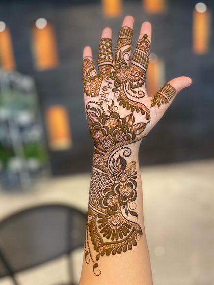 This beautiful Arabic floral design has the name 'Mohit' cleverly integrated into the pattern on the palm. Can you spot it?