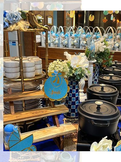 A charming blue-themed setup for a baby boy's welcome party. The buffet table is adorned with cute decor, and our cast iron pots keep the main courses perfectly warm.