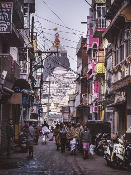 a temple visible at the end of a busy street in puri. this photo is about leading the eye towards a central point of interest, a fundamental part of user navigation design.